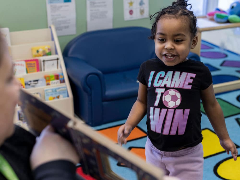 Woman reading a book to young girl