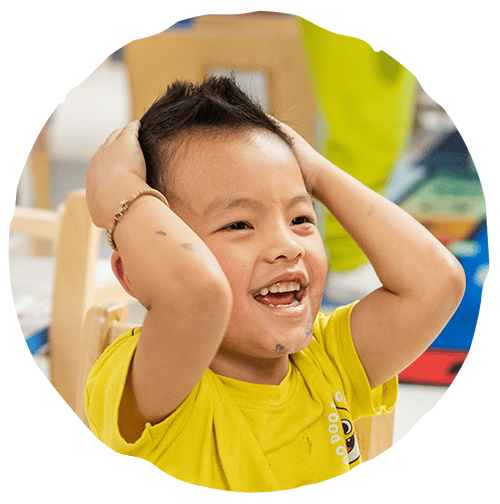 Young boy holding his head smiling